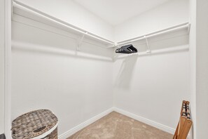 Ein Eckkleiderschrank mit Schuhaufbewahrungsgestell, ein kleiner runder Tisch und ein Stuhl.