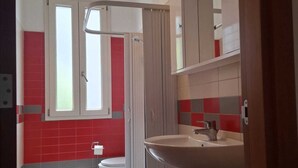 Ein Badezimmer mit Toilette, Waschbecken und Duschbereich.