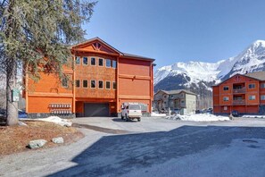 Ein mehrstöckiges Gebäude mit Garage, umgeben von schneebedeckten Bergen.