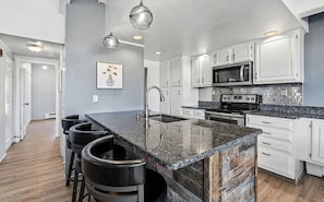 A modern kitchen with white cabinets, a granite countertop, and stainless steel appliances. - Lake Dillon Escape...Mountain Views (Dillon)