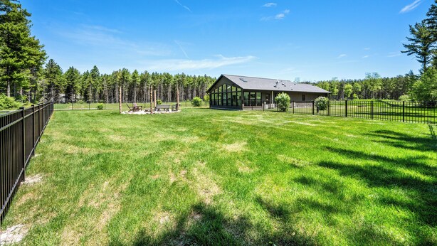 A house with a large lawn, a gazebo, and a forest in the background. - Modern Rustric Retreat w/Fenced Yard + 4-Season Room (Baileys Harbor)