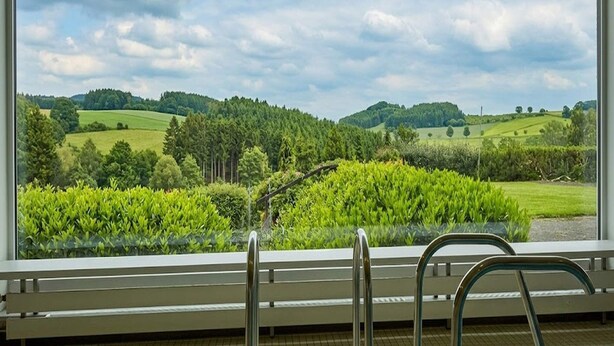 A room with a large window overlooking a green landscape with trees and hills. - 2 Person Holiday Park Home in Willingen (Willingen)