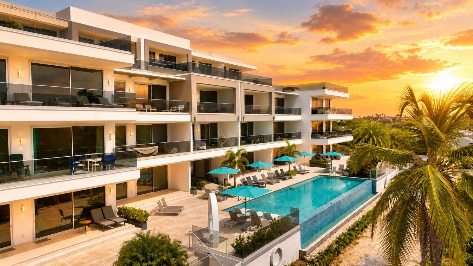 A multi-story hotel with a rooftop pool, outdoor seating, and palm trees.