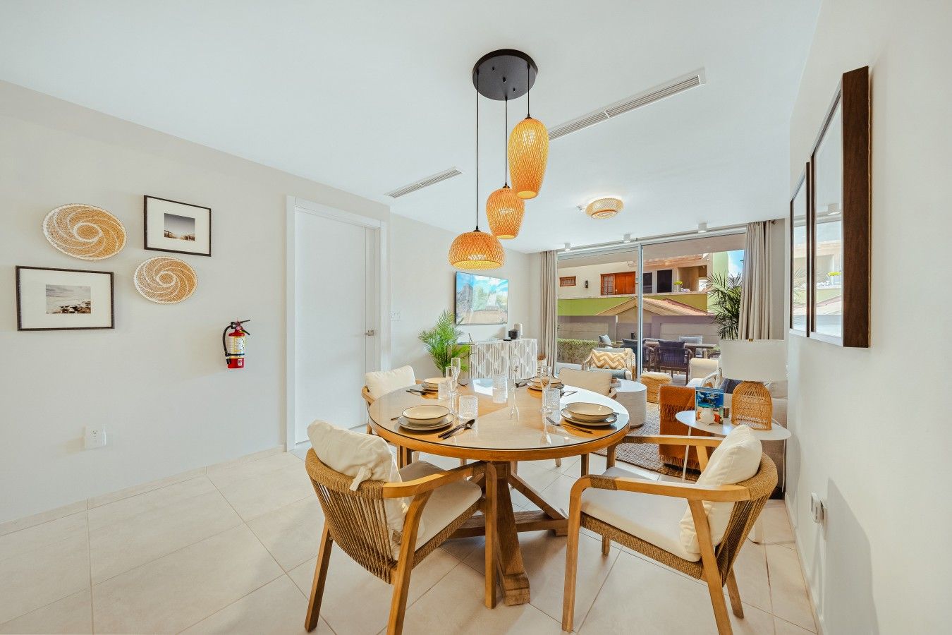 Un espace repas comprenant une table ronde, des chaises et des luminaires suspendus.