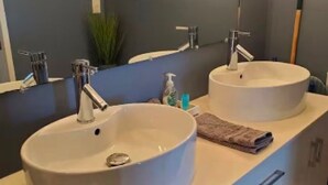 Une salle de bain avec deux lavabos, un miroir et une serviette posée sur le comptoir.