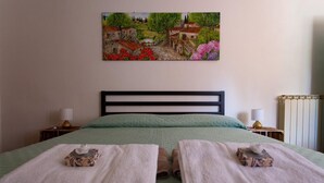 A bedroom with a bed, two bedside tables, a painting on the wall, and a radiator. - Apartment not far from the center of Arezzo, suitable for both couples and families (Arezzo)