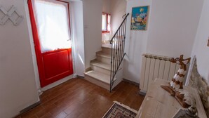 A staircase leading to an upper floor, a red door, a radiator, and a wall-mounted picture. - Apartment not far from the center of Arezzo, suitable for both couples and families (Arezzo)