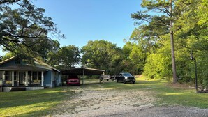 A house with a porch, a covered garage, and a gravel driveway.