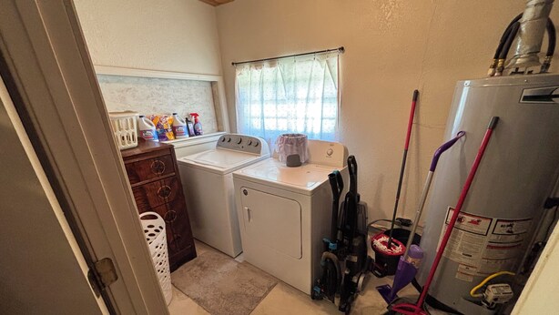 A laundry room with a washing machine, dryer, and various cleaning supplies. - Peaceful 3 bedroom home and room for 4 boats near Atoka, McGee, and Sardis Lake (Stringtown)
