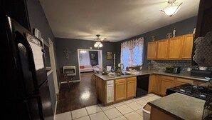 A kitchen with wooden cabinets, a stove, and a refrigerator. - Peaceful 3 bedroom home and room for 4 boats near Atoka, McGee, and Sardis Lake (Stringtown)