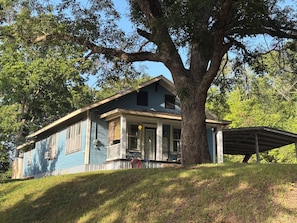 A two-story house with a porch, large tree, and a covered porch area. - Peaceful 3 bedroom home and room for 4 boats near Atoka, McGee, and Sardis Lake (Stringtown)