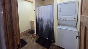 A laundry room with a washing machine, a drying rack, and a shower curtain. - Wonderful 3-bedroom house in Dubois perfect for your getaway peace and quiet (Dubois)