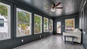 A room with large windows, a ceiling fan, and a bench. - Blackbeard's Isle -  9 beds, 6BR/3BA - 500 ft from Beach (Isle of Palms)