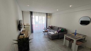 Ein modernes Wohnzimmer mit einer Couch, einem kleinen runden Tisch und einem Blumentopf.
