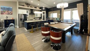A modern living room with a pool table, bar stools, and a sofa. - New on VRBO! New Construction, Stylish Mega RV Garage House (Lake Havasu City)