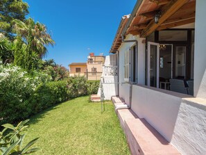 A residential property with a well-maintained lawn, a patio with outdoor seating, and a view of neighboring buildings. - Vacation home Calma by Interhome (Porto Cristo)