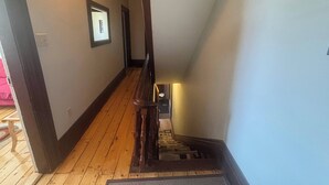 A wooden staircase with a handrail leading to a landing. - Pentz Howe House Apartment, (Charlottetown)