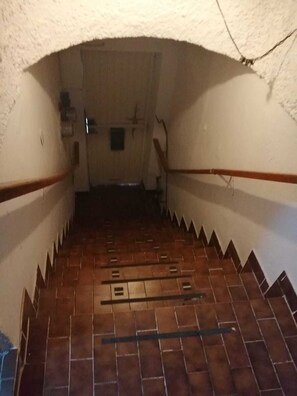 Eine schmale Treppe mit Fliesen, die zu einer höheren Ebene führt.