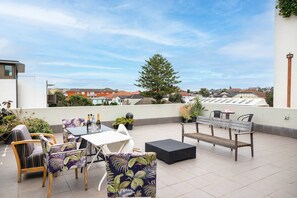 A rooftop terrace with outdoor furniture, potted plants, and a view of the neighborhood. - Bondi Studio, Rooftop Terrace | 2 Min Walk to Beach, King Bed, AC (Bondi Beach)