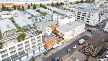A coastal hotel with multiple floors, a rooftop terrace, and a view of the beach.