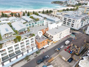 Ein Hotel an der Küste mit mehreren Etagen, einer Dachterrasse und Blick auf den Strand.