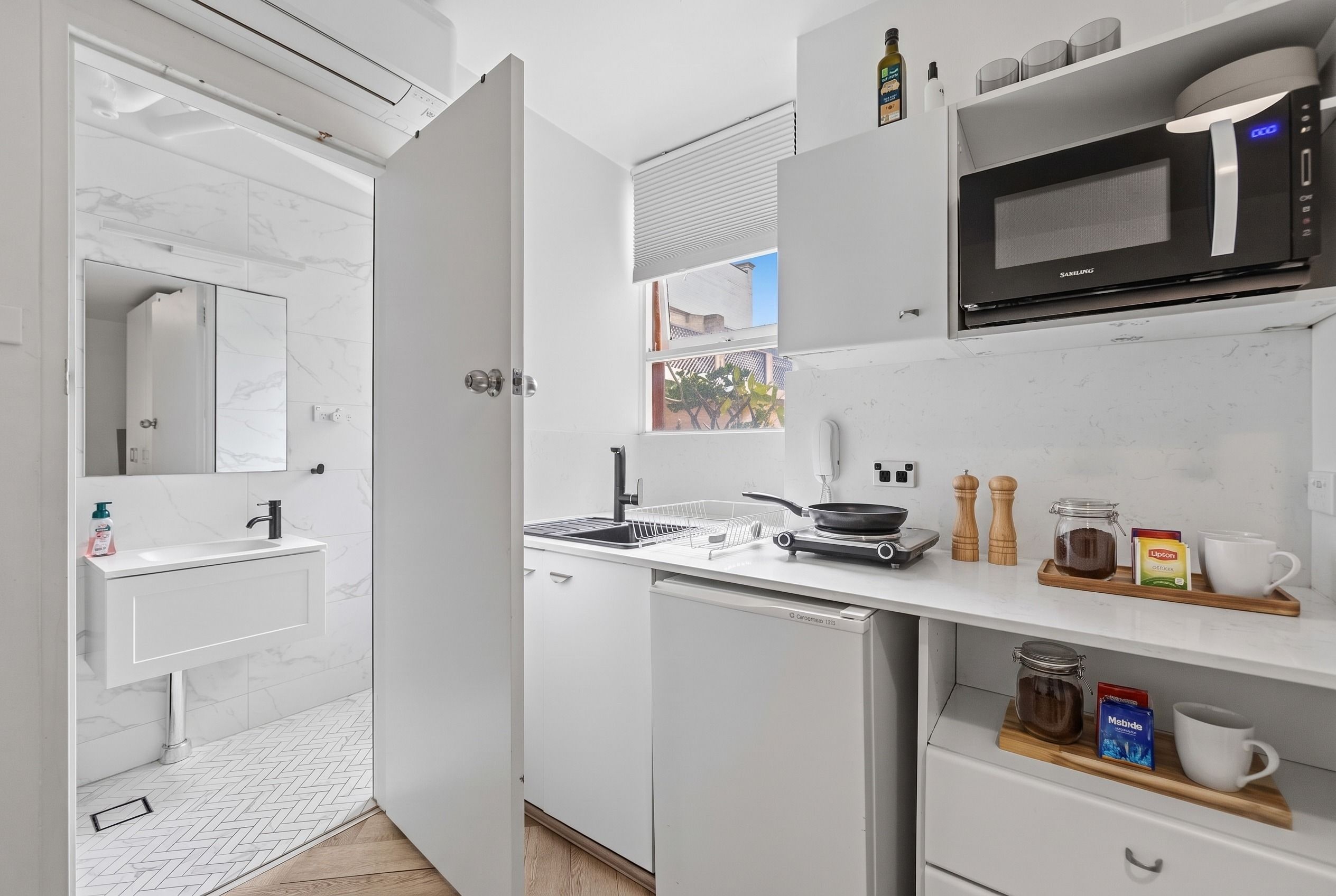 Kitchenette with cooktop, microwave, bar fridge, tea and coffee