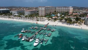 Une station balnéaire dotée d’un port de plaisance, d’une plage et de bâtiments d’hôtel.