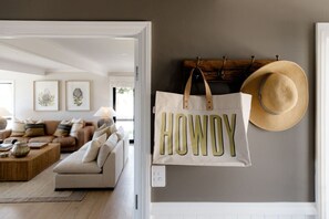 A living room with a sofa, coffee table, and wall-mounted hat rack. - The Farmhouse; Hauraki Views & Tranquil Luxury (Matakana)