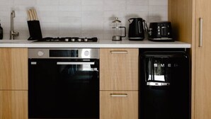 Eine moderne Küche mit Holzausstattung, einer Mikrowelle, einem Herd, einem Backofen und einem Geschirrspüler.