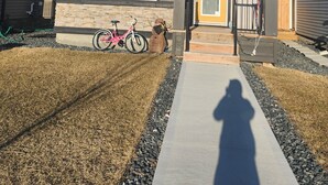 Une maison à deux étages avec une façade en pierre, un numéro bien visible « 757 » et un vélo garé devant.