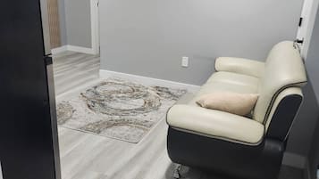 Ein modernes Wohnzimmer mit Sofa, Teppich und Kühlschrank.