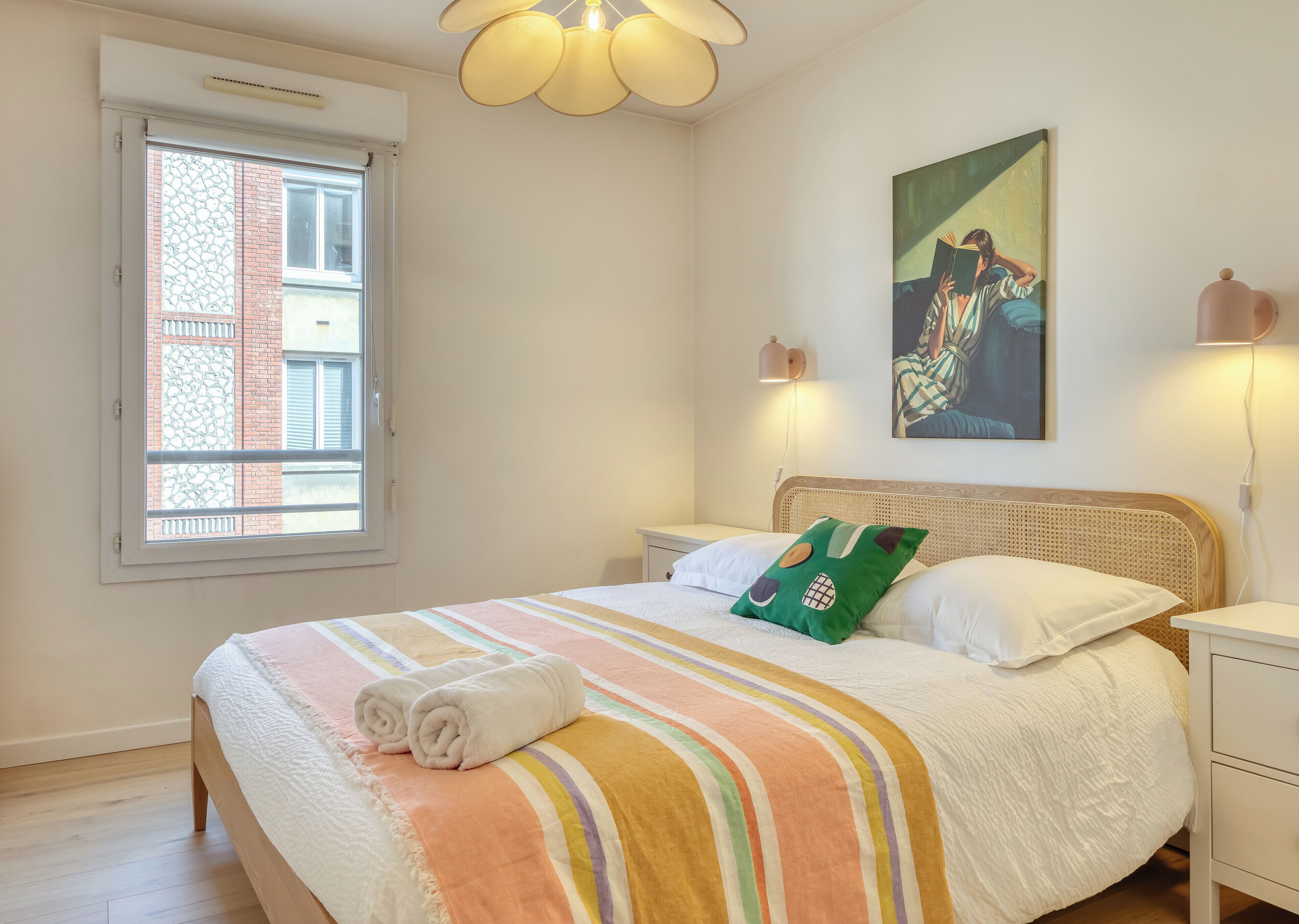 Une chambre à coucher avec un lit, une fenêtre, un tableau et une lampe de chevet.