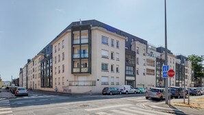 Un edificio de varios pisos con un diseño arquitectónico moderno, con balcones y ventanas amplias.