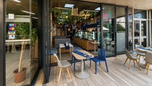 Un caffè interno con posti a sedere, un bancone e un neon.