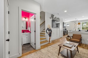 A modern interior with a kitchen, dining area, and a staircase leading to a second floor. - Some Things Just Go Better Together - Nash homes sleep 20! (Nashville)
