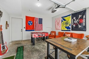 A room with a foosball table, a guitar, and various flags. - Some Things Just Go Better Together - Nash homes sleep 20! (Nashville)