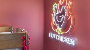 A neon sign of a chicken with flames and the text 'HOT CHICKEN' on a red wall. - Some Things Just Go Better Together - Nash homes sleep 20! (Nashville)