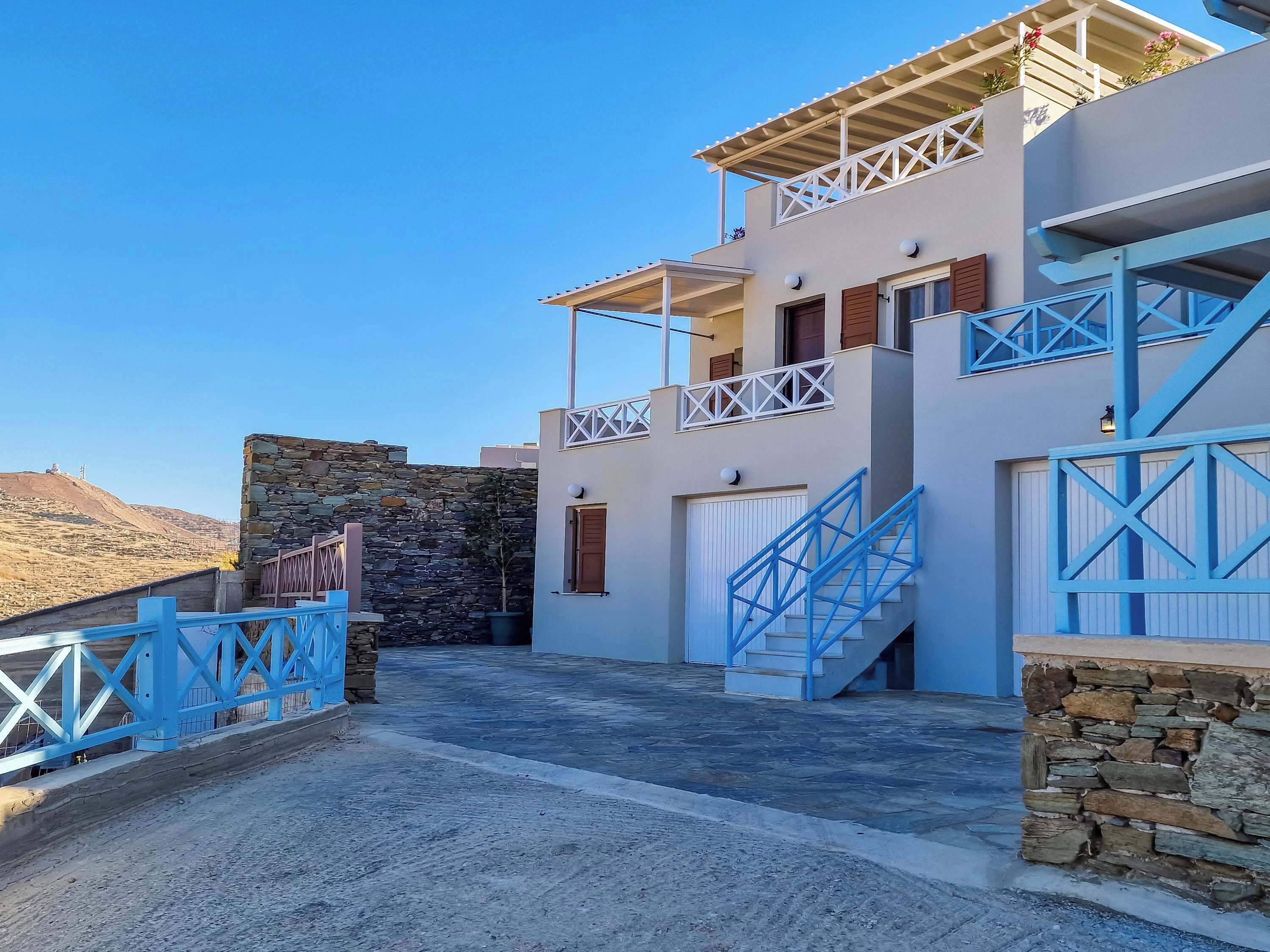 White villa exterior with Cycladic character, and a clear sense of arrival at the property.