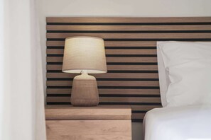 A bed with a white pillow and a wooden bedside table with a lamp. - Syros Sun Villa - Terrace Open Views near Airport (Manna)