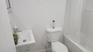 Une petite salle de bain comprenant des toilettes, un lavabo et un espace douche.