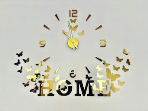 A wall clock with a 'HOME' sign and butterfly decorations. - Spacious 2-bed House in Walker (Newcastle upon Tyne)