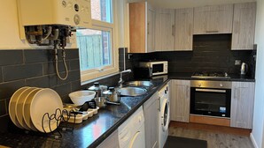 Une cuisine moderne équipée d’un lave-linge, d’un four à micro-ondes et d’une cuisinière.