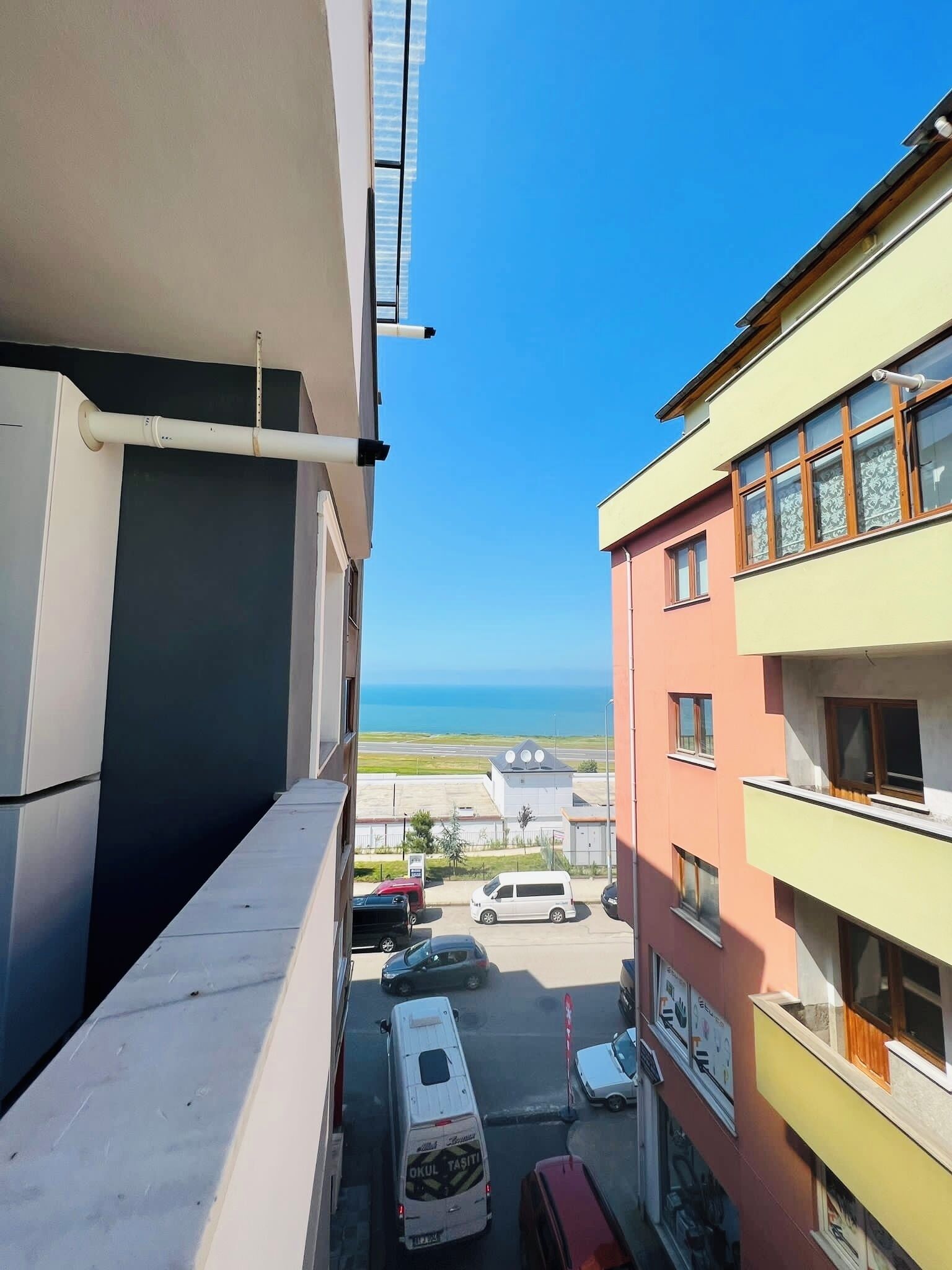 Un estrecho callejón entre edificios, con vista despejada al mar.