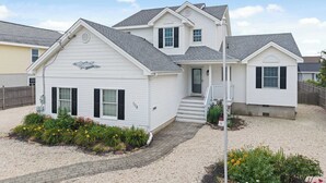A two-story house with a front porch, a small garden, and a gravel driveway. - 1 Block to Beach, 4BR Ship Bottom LBI, Sleeps 8, Walk to All (Ship Bottom)