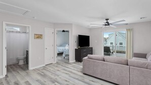 A modern living room with a grey sofa, a flat-screen TV, and a ceiling fan. - 1 Block to Beach, 4BR Ship Bottom LBI, Sleeps 8, Walk to All (Ship Bottom)