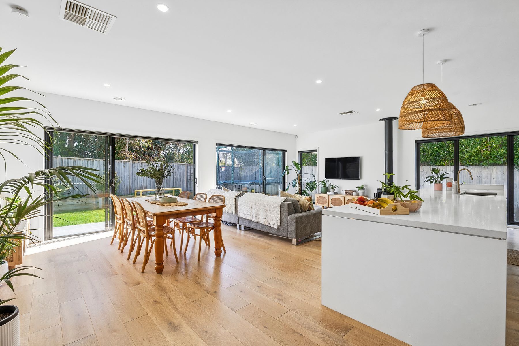 A spacious kitchen with a dining area, large windows, and a modern design.