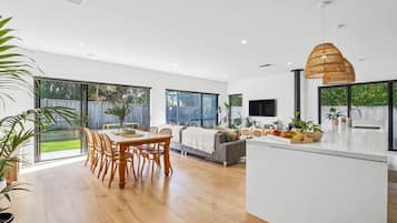 A spacious kitchen with a dining area, large windows, and a modern design.