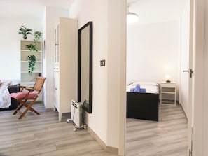 Ein modernes Schlafzimmer mit Bett, Nachttisch und einem Sessel.