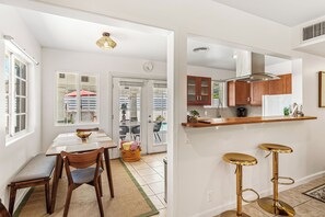 Een moderne keuken met houten kastjes, een aanrecht en twee gouden krukken.