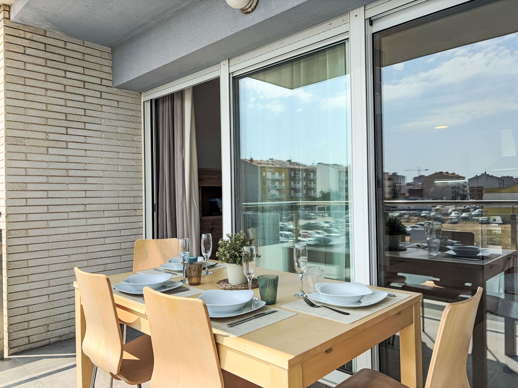 A dining area with a table set for four, large windows, and a view of the cityscape.